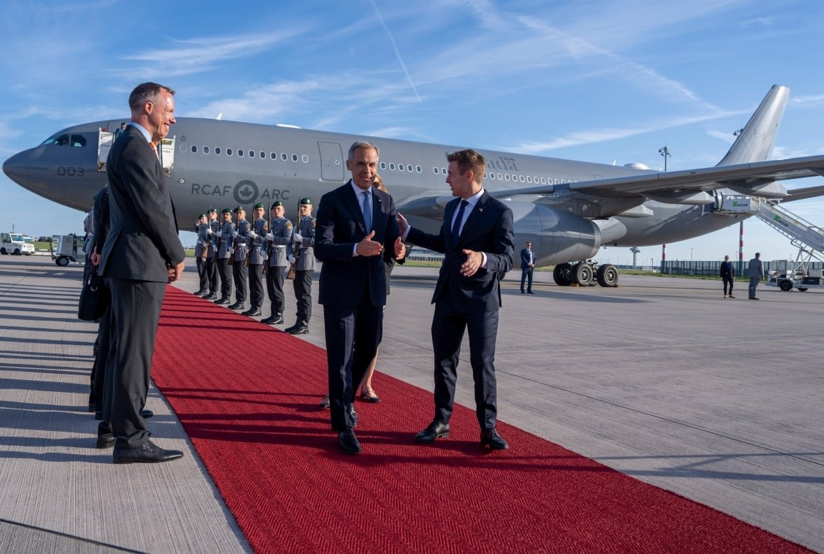 A group of people walking from an airplane on a red carpet.