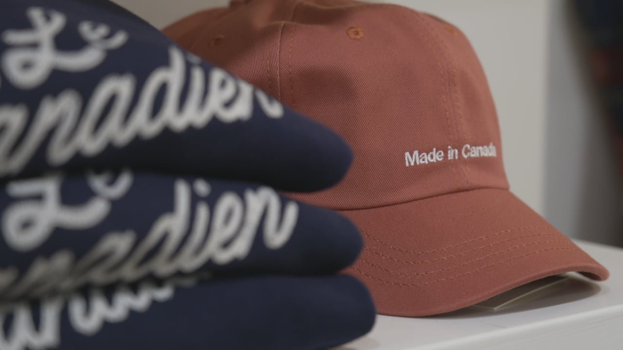 Sweaters blurred and a hat in the background that says Made in Canada.