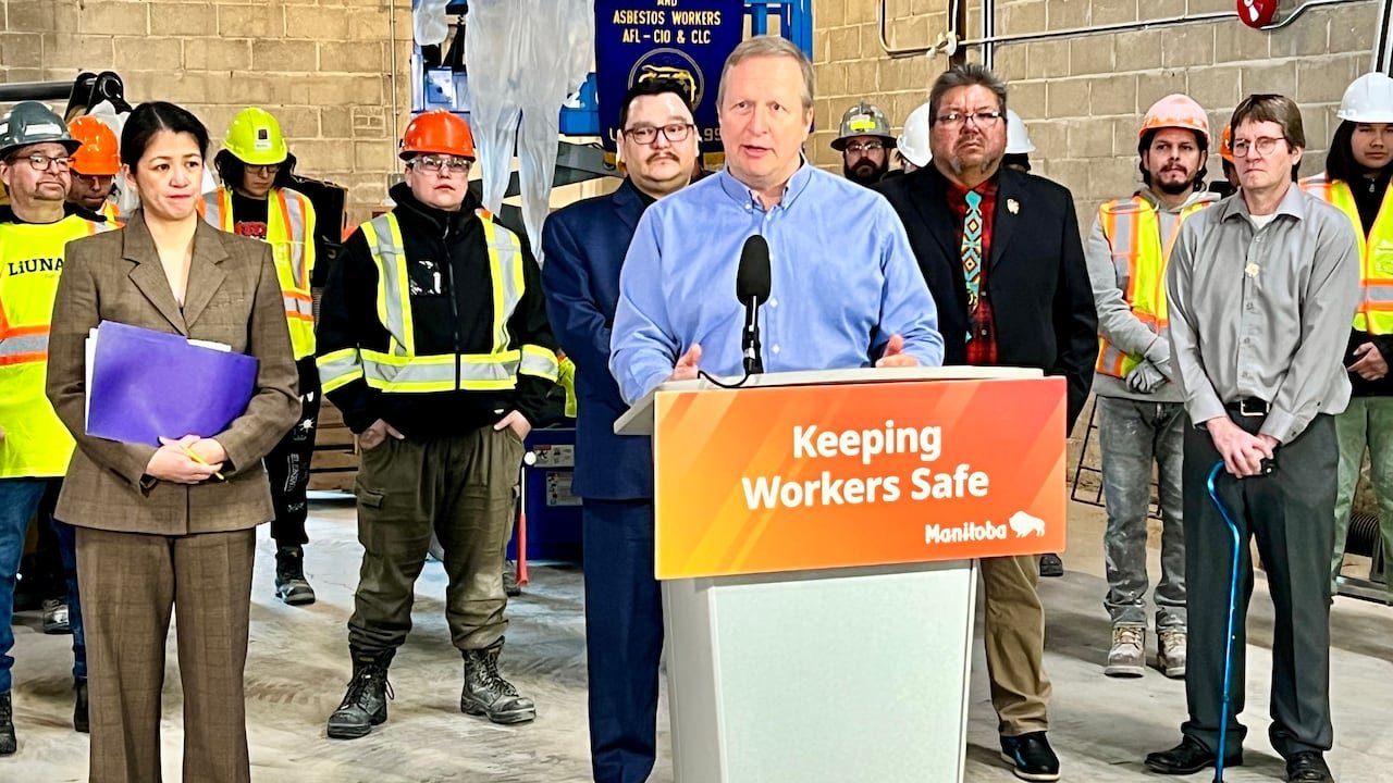 default-157 A man wearing a blue shirt speaks on a podium.