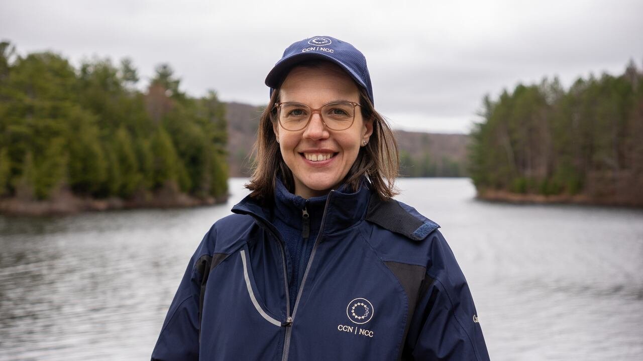 A person stands by a lake.