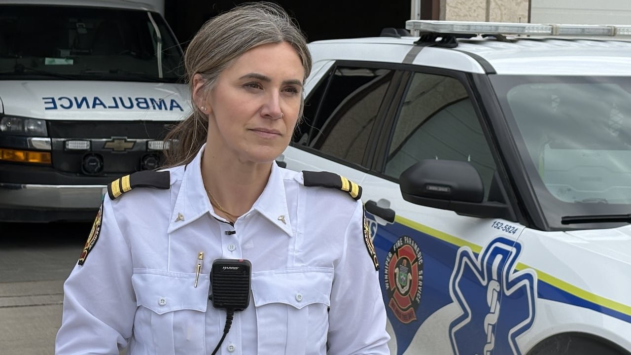 A woman standing outside in front of a paramedic car.