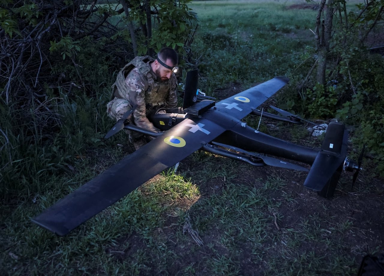 default-70 A Ukrainian serviceman stands over a large drone and prepares it to be launched towards Russian targets.